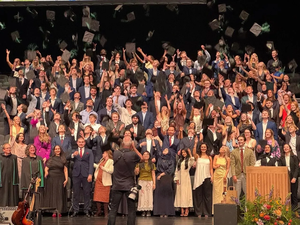 Graduates throwing their caps in the air at the end of the ceremony.